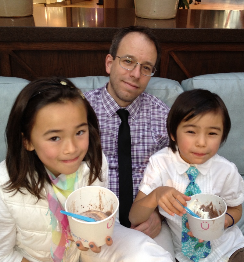 Tim sitting on sofa with daughters